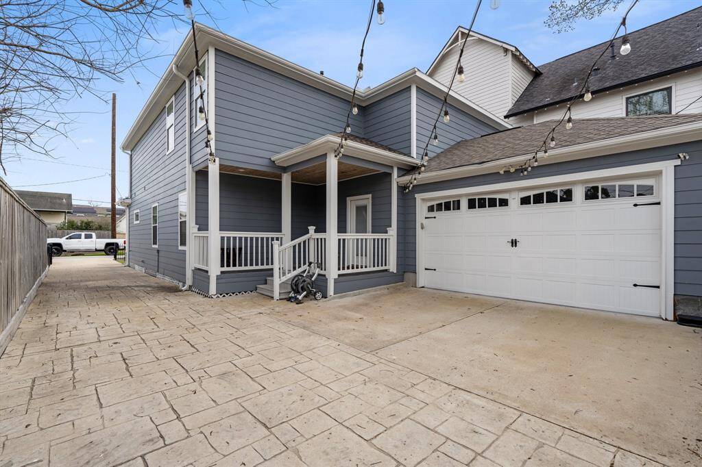 A long, beautifully paved private driveway leads to a two-car garage with epoxy flooring & two charging stations, offering ample parking and storage. A charming covered back porch provides a shaded retreat, enhancing the home’s welcoming outdoor spaces.