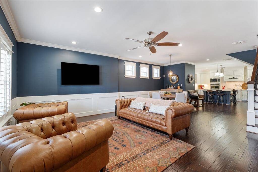 The spacious living and dining area boasts soaring ceilings, wainscoting, and abundant natural light, creating an elegant and airy ambiance. The seamless flow leads directly into the chef’s kitchen, perfect for entertaining.