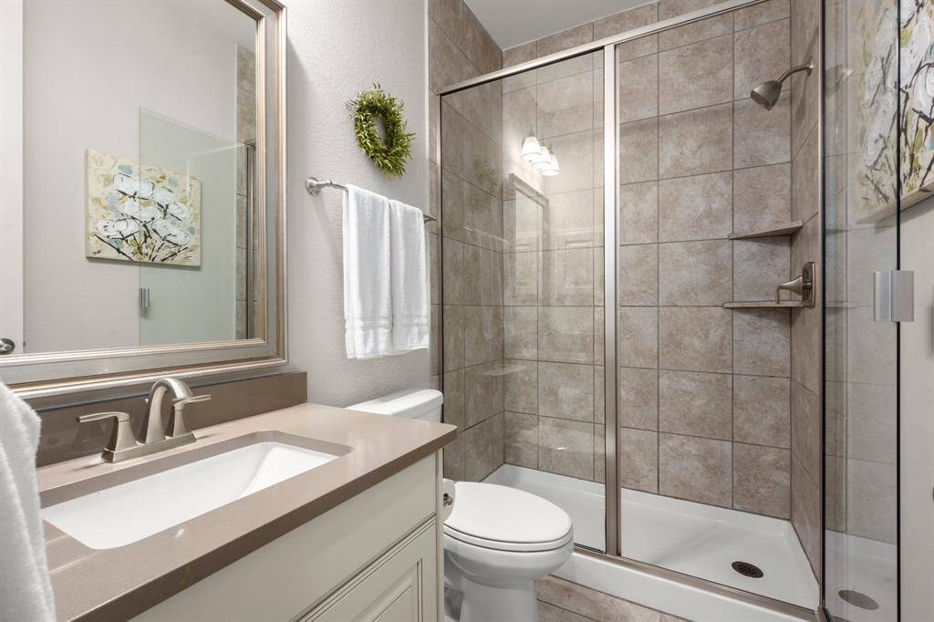 This downstairs guest retreat features hardwood floors, window blinds, and a ceiling fan for year-round comfort.
