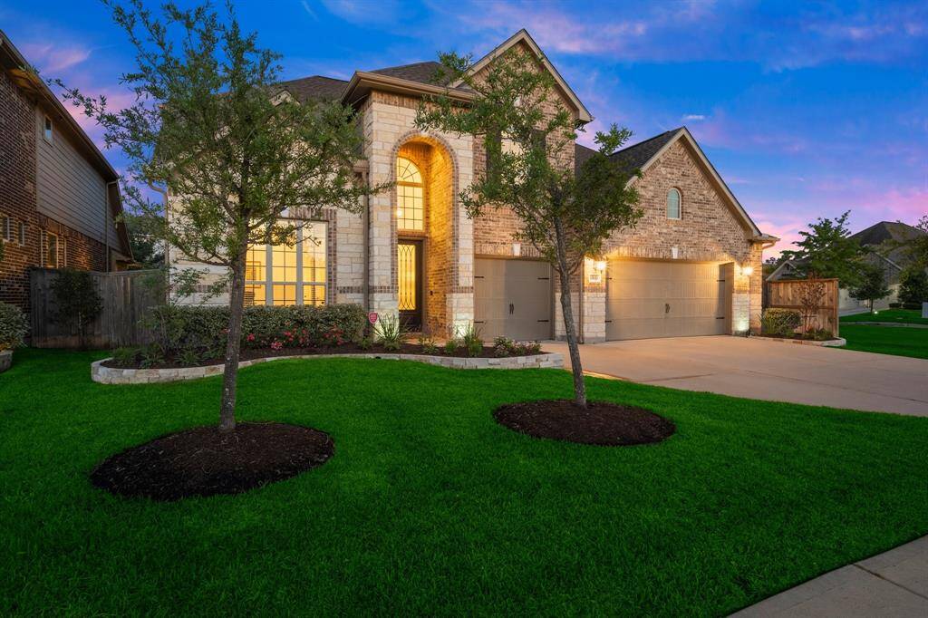 This beautifully landscaped stone and brick two-story home sits proudly on a spacious corner lot.