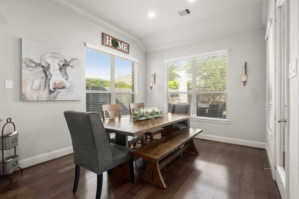 Enjoy your morning coffee in an expansive breakfast room with hardwood flooring and panoramic windows overlooking the backyard.