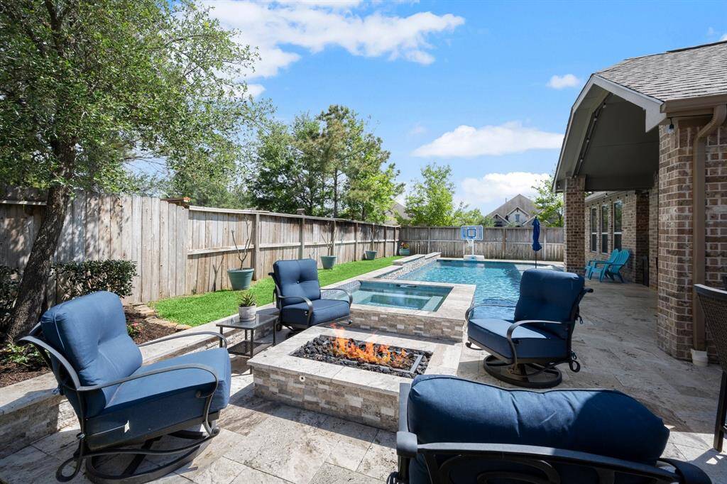 Step outside to your private backyard oasis featuring a PebbleTec pool with attached spa, perfect for Texas summers.