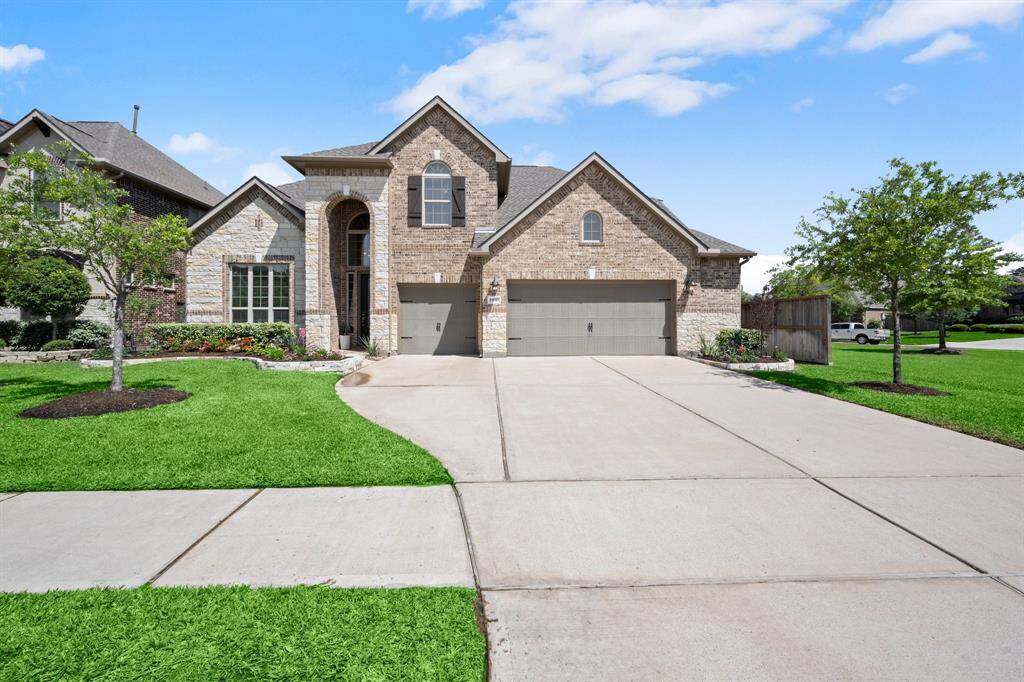 The three-car garage includes a generous side bump-out for added storage and is paired with an extended driveway for extra parking.
