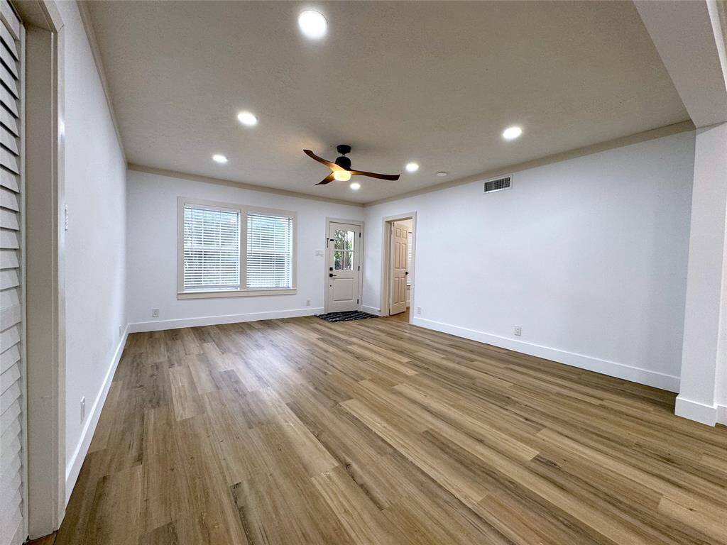 View of living room and front door, includes ceilng fan with remote.