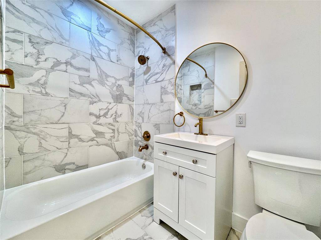 Beautifully updated bathroom with golden accents.