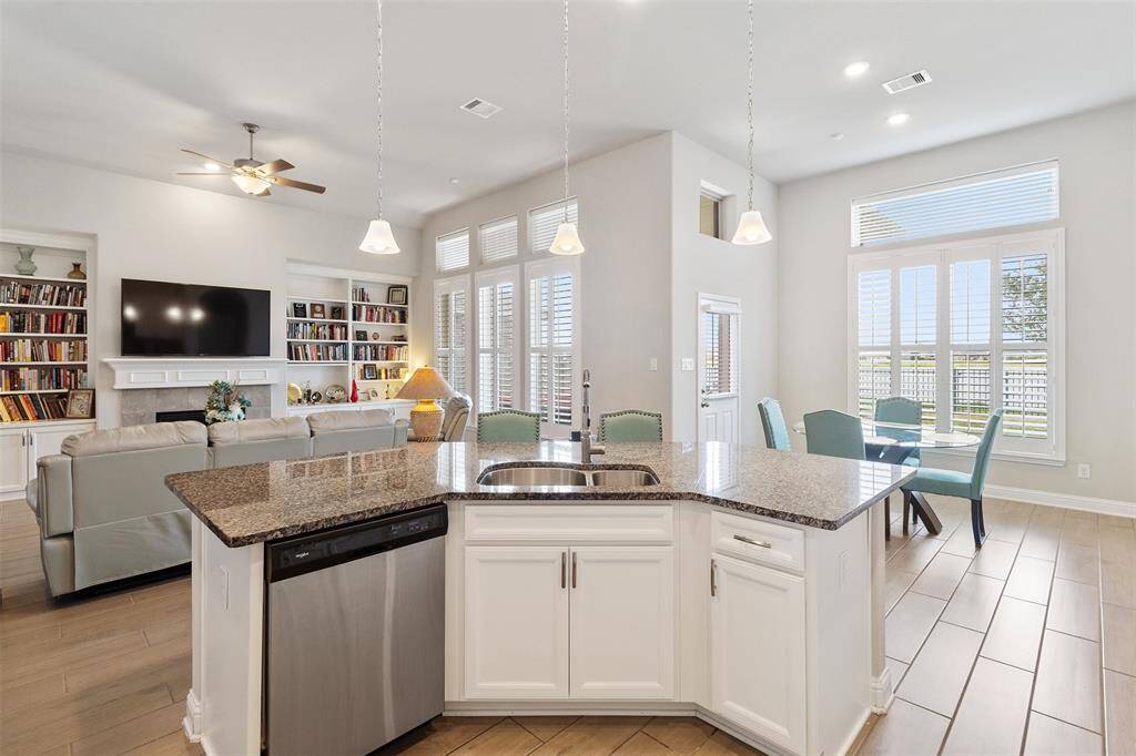 Chef's eat-in kitchen features an oversized island with seating, stainless steel appliances, walk-in pantry and lengthy granite countertops