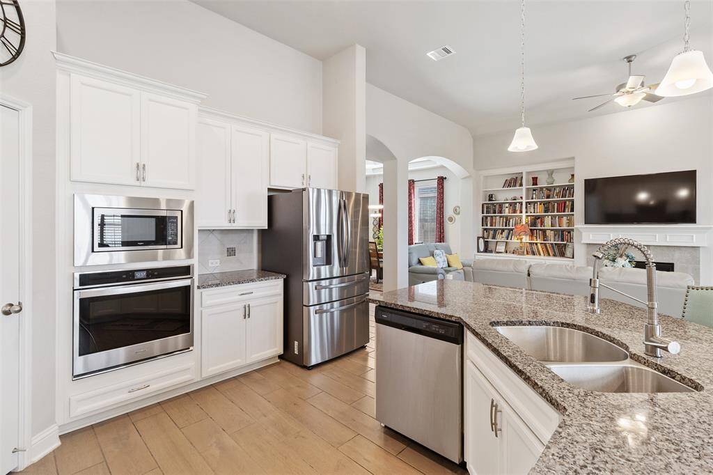 Chef's eat-in kitchen features an oversized island with seating, stainless steel appliances, walk-in pantry and lengthy granite countertops