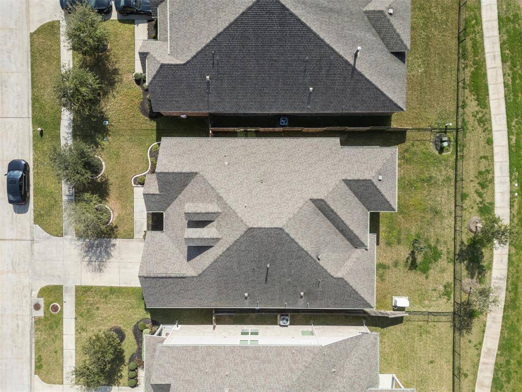 Aerial view of the home backed up to the lake with gate to trail