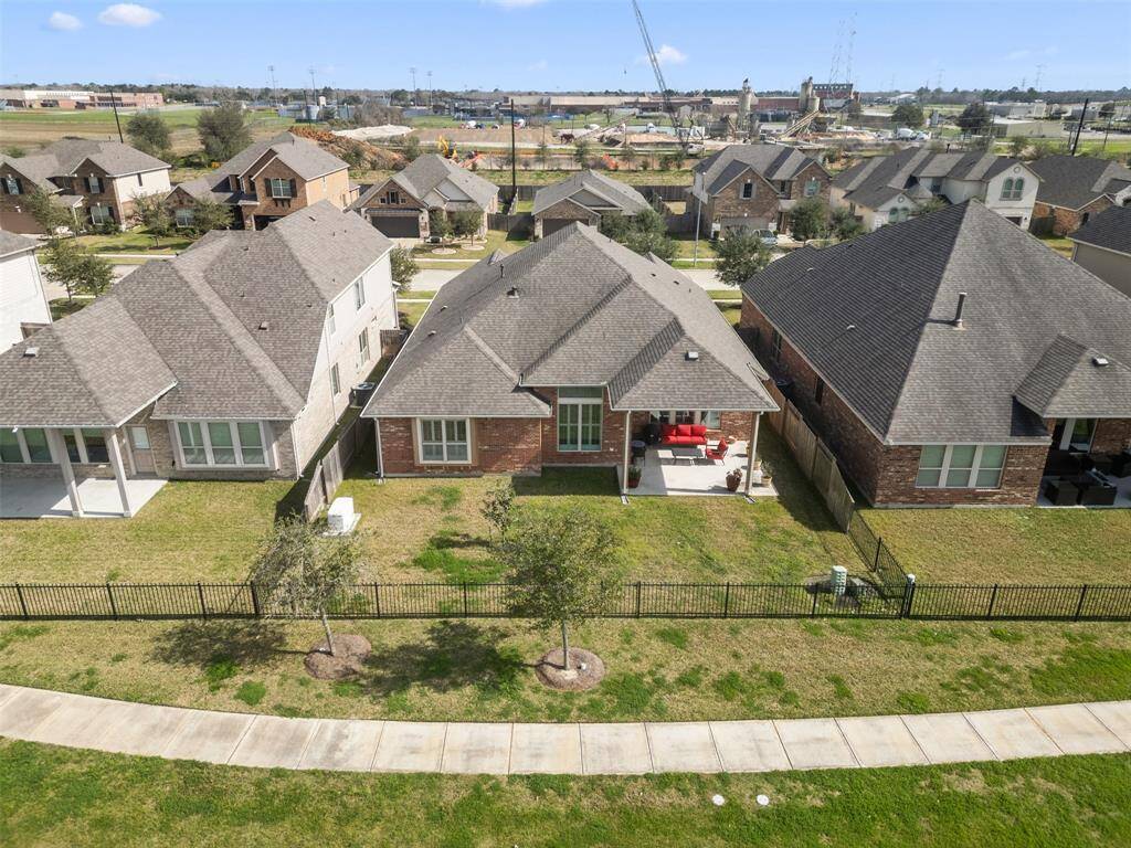 Aerial view of the home backed up to the lake with gate to trail