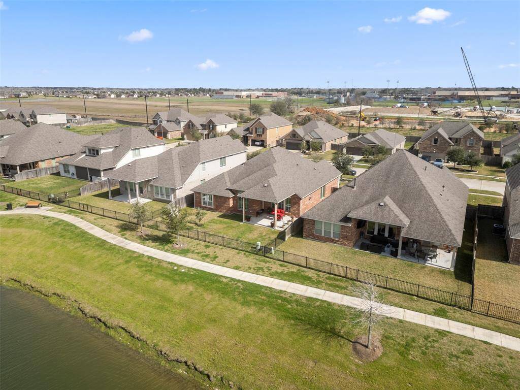 Aerial view of the home backed up to the lake with gate to trail