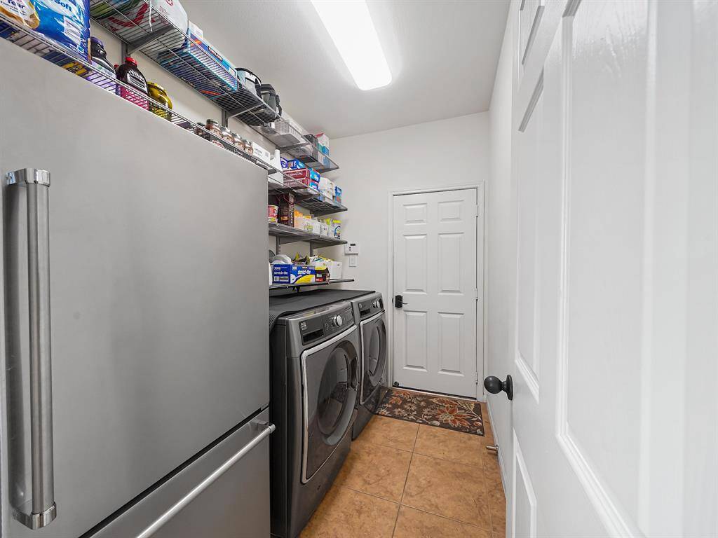Utility room features Elfa organization system and has ample room for a second refrigerator!