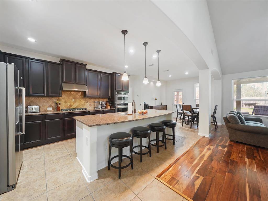 The gourmet island kitchen is a chef's delight, featuring premium Kitchen Aid appliances, stunning granite countertops, a large pantry, and an oversized island offering plenty of prep space and additional seating.