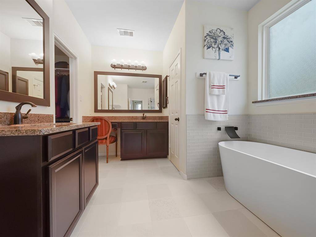 The ensuite bathroom has been completely renovated with a luxurious soaking tub, a separate shower, and his and her vanities, creating a spa-like experience.