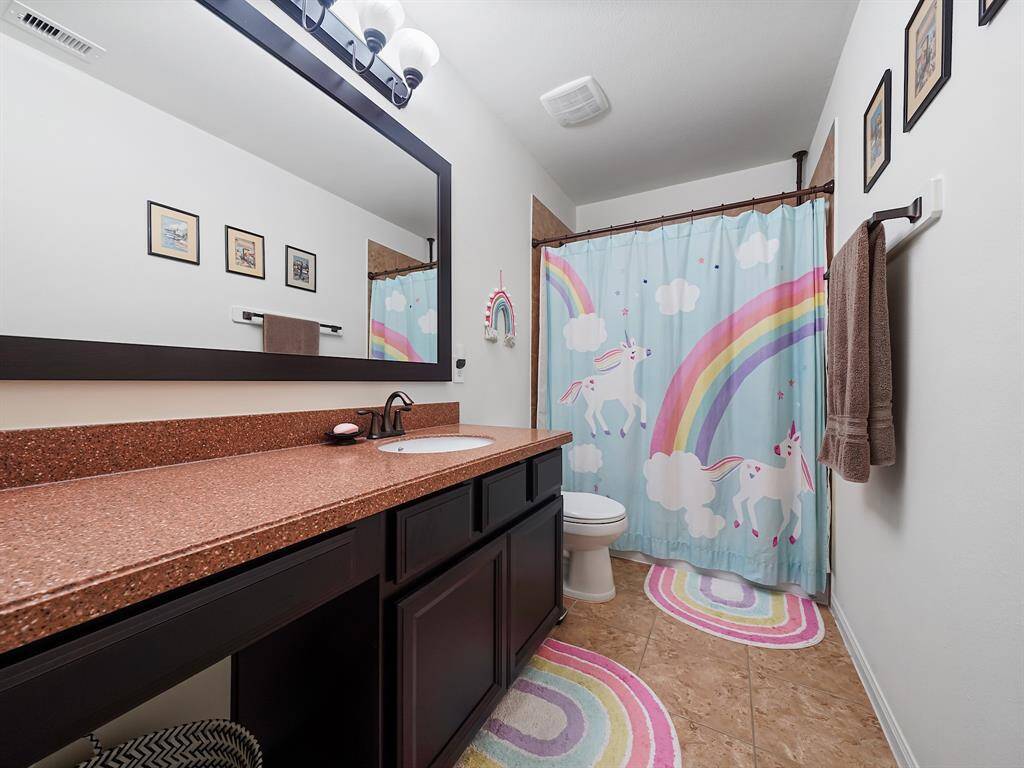 Secondary bathroom upstairs offers extended vanity with seating area and tub/shower combo!