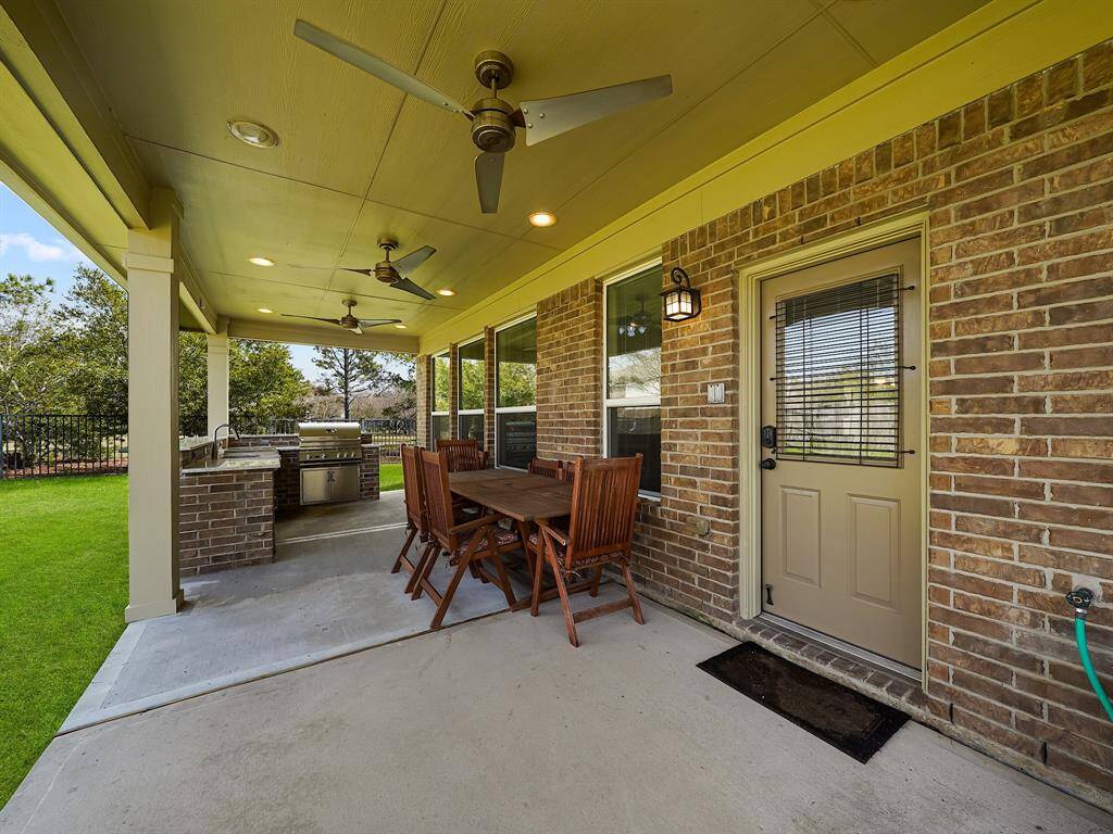 The cul-de-sac lot provides an enormous backyard with an extensive covered patio featuring an outdoor kitchen, perfect for outdoor entertaining.