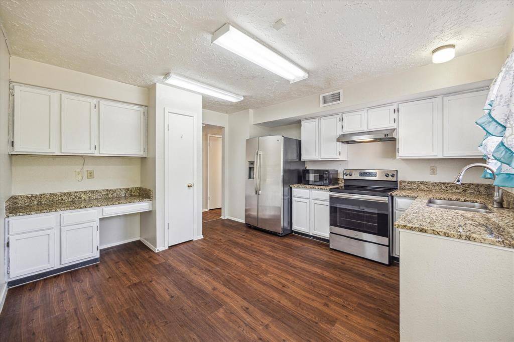 Stainless steel appliances, granite countertops and white cabinets + extra storage for all of your cooking needs