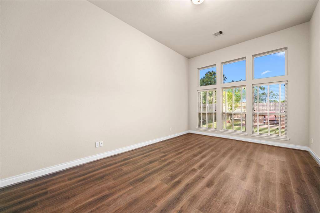 The expansive primary bedroom boasts soaring ceilings and a stunning wall of windows that showcase views of the backyard. This serene retreat is filled with natural light and has easy access to the ensuite bath.