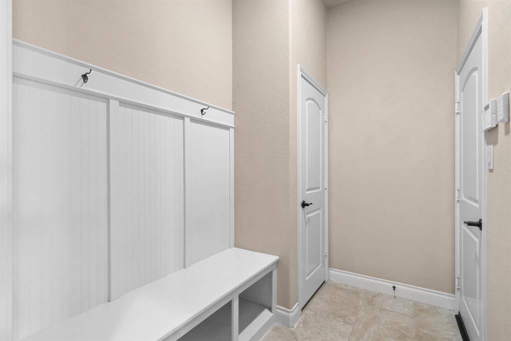 Conveniently located near the garage entry, this mudroom includes built-in hooks and a bench, perfect for storing shoes and bags. It’s a smart and stylish addition for everyday organization.