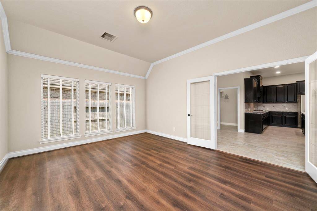The spacious flex room is ideal for a home office or home gym. French doors and a full wall of windows provide an open, airy feel while maintaining privacy from the main living spaces.