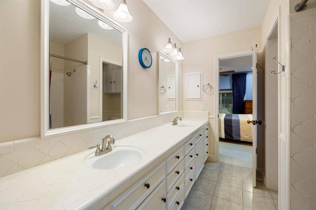 This is the Hollywood Bath between 2-secondary bedrooms upstairs.  Large vanity is ideal for 2 residents or guests with a tub/shower.  Note the framed mirrors and stylish lighting.