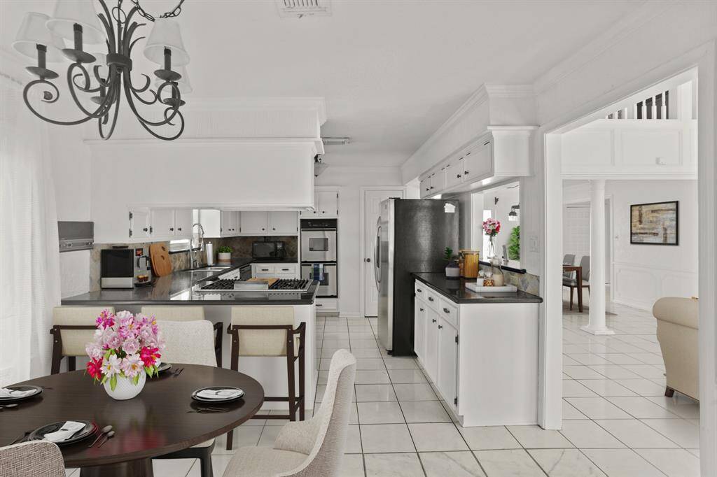 Virtually Staged: Enjoy a meal with your family in this lovely breakfast nook, flowing seamlessly into the kitchen.