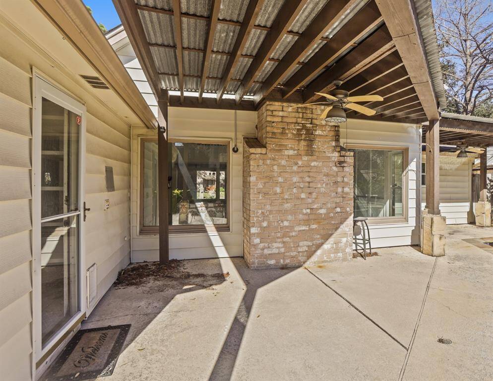 This covered patio with a ceiling fan is the perfect place to watch the gorgeous Texas sunset from this stunning backyard!