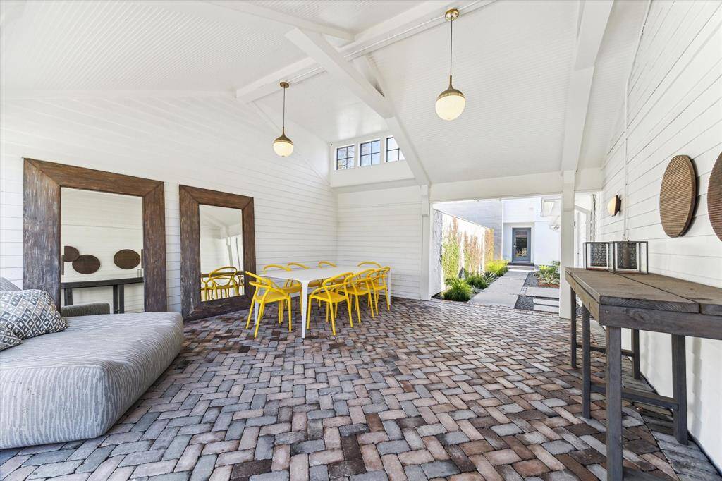Living area covered by the roof connecting 2023 to the versatile back structure. Imagine expanding your living or dining area here or utilizing this space as a covered outdoor patio. The possibilities are endless with this added space!
