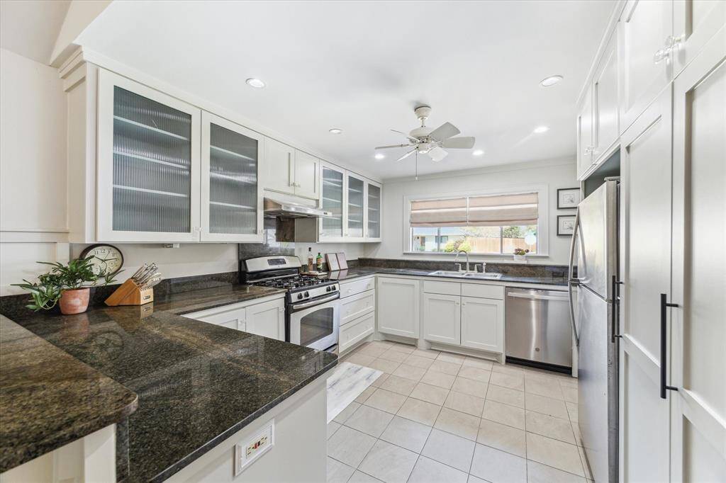 Sophisticated kitchen featuring a bar-height counter that seamlessly flows into the open living space, creating an inviting setting for effortless entertaining and casual gatherings.