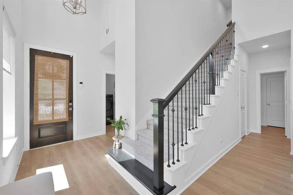Beautiful banisters elevate the look of the stairway, while the carpeted steps add a soft touch that many find more comfortable than hardwood. The utility room and access to the garage are located on the opposite side.