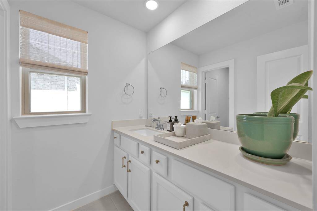 The upstairs full bathroom offers great functionality with a long countertop, a tub/shower combo with tile surround, and yes - more natural light