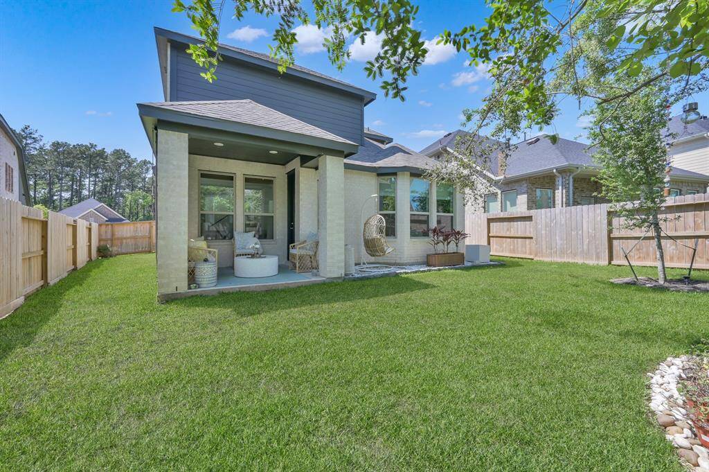 Enjoy the covered back porch just off the kitchen and across from the primary bedroom, offering a peaceful view of the back yard