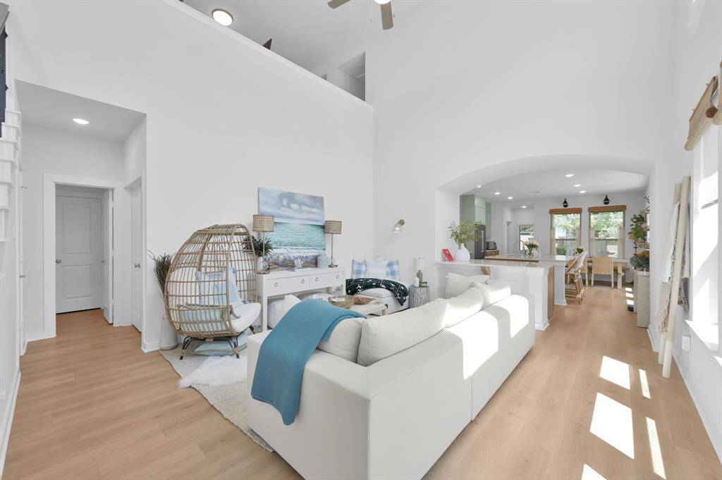 The family room features a 2-story ceiling, gorgeous luxury vinyl plank flooring, a wall of windows offering tons of natural light, and open to the kitchen