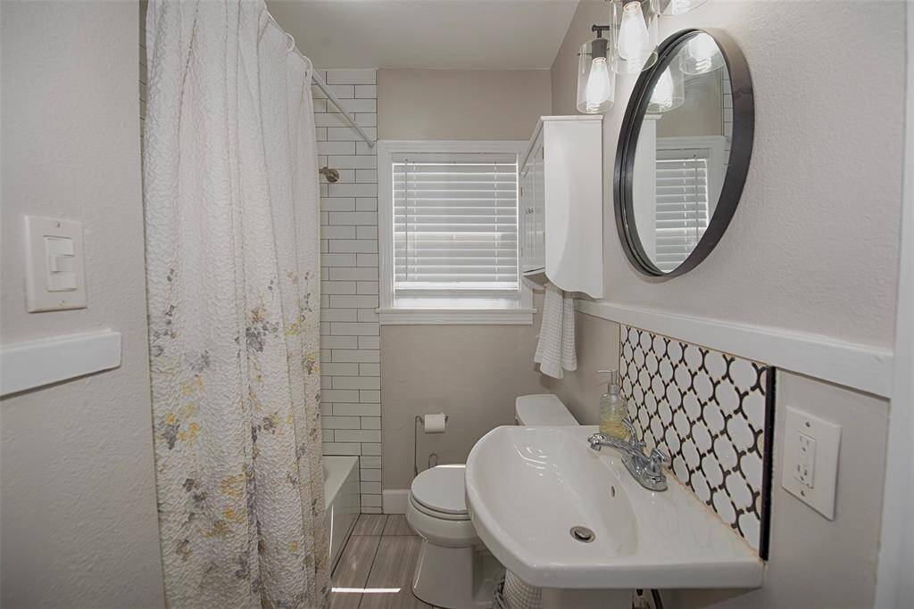 Updated bathroom with amazing tile work - porcelain tile floors and a large tub with shower.