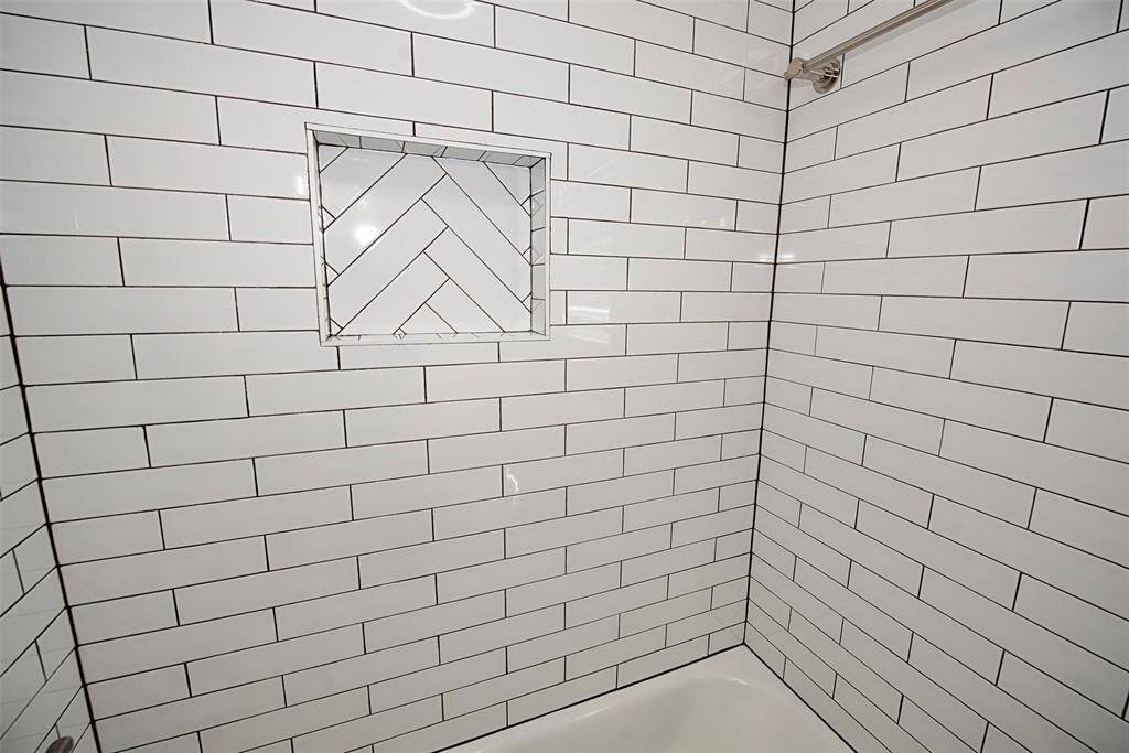 The tub/shower has newly installed vintage look subway tile surrounding the perimeter.  A handy niche for your bath essentials has been built right in for your convenience.