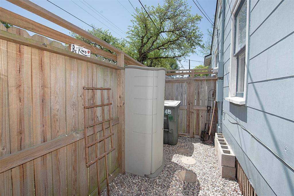 Along the alley side of the home is a rock area and small shed for storing landscaping tools. The gate to the alley and front yard is just beyond the shed.