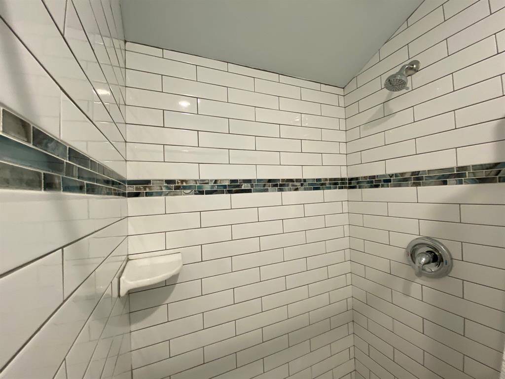 Mini-subway tile shower surround with penny tile floor harken back to the 1940s when the neighborhood was first built.