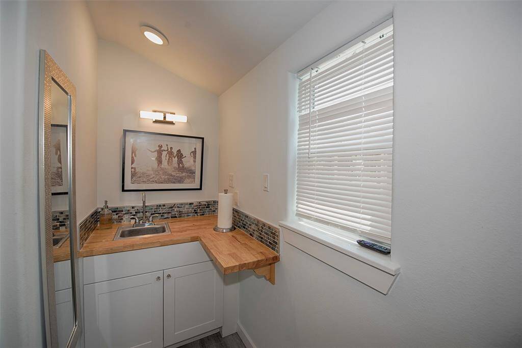 The butcher block counter is perfect for setting up appetizers or refreshments if using as a game room. Great storage below as well. Studio bathroom features a roomy walk in shower with subway tile and penny tiled floors reminiscent to the 40's style when the main house and neighborhood was first built.