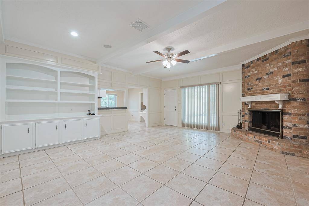 Living Room with custom built-in shelving and brick fireplace.