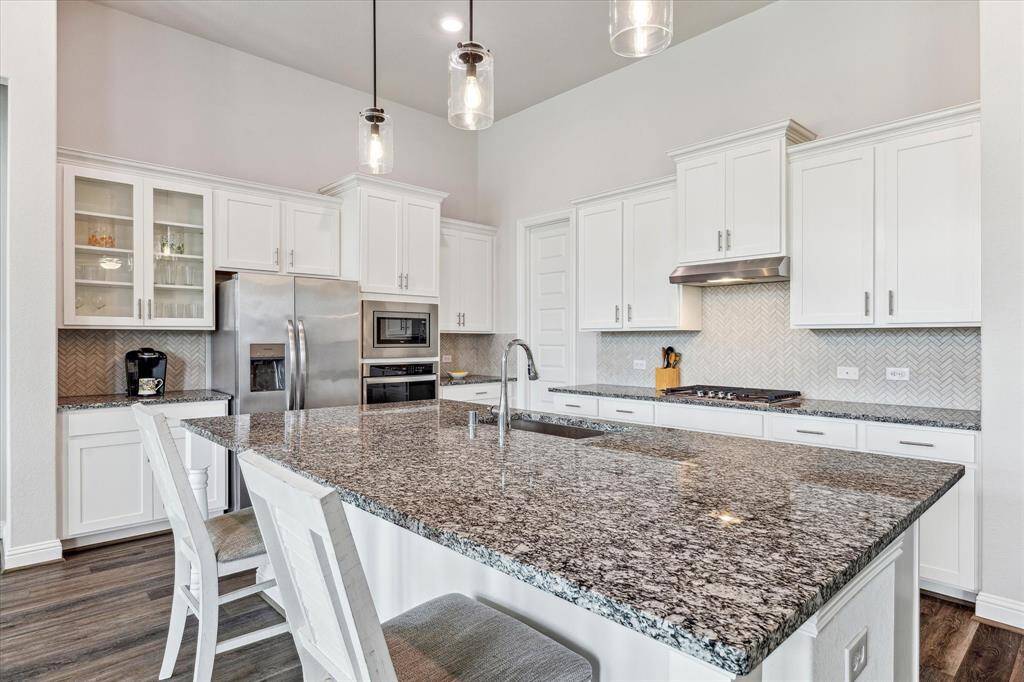 Expansive storage and cabinetry in this kitchen, with herringbone backsplash