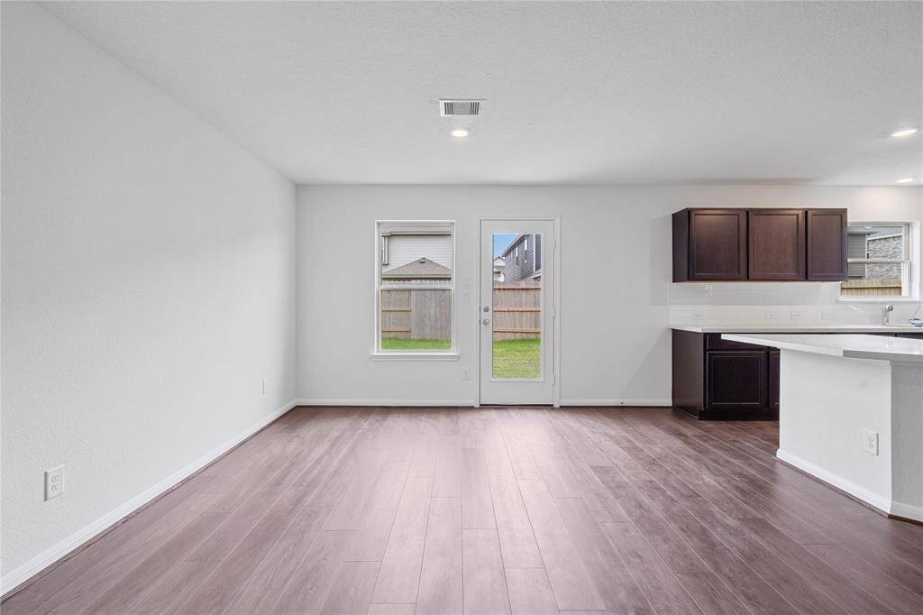 This lovely dining area is perfect for starting the day out on the right foot! This space showcases custom paint, high ceilings, recessed lighting, large window, and access door to your back yard!