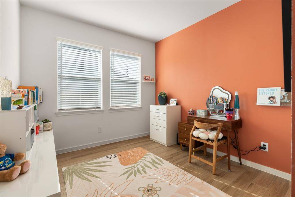 Cozy secondary bedroom with vibrant accent wall, and versatile space for relaxation.
