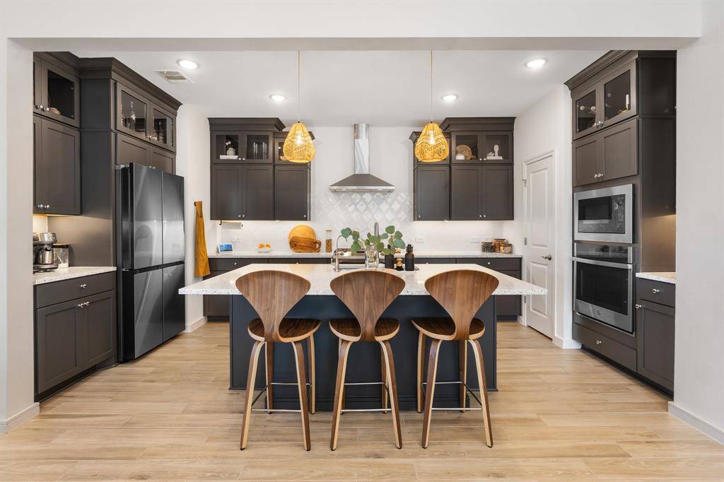 Elegant kitchen featuring lighted upper cabinetry, granite countertops, under cabinet lighting and modern stainless steel appliances.