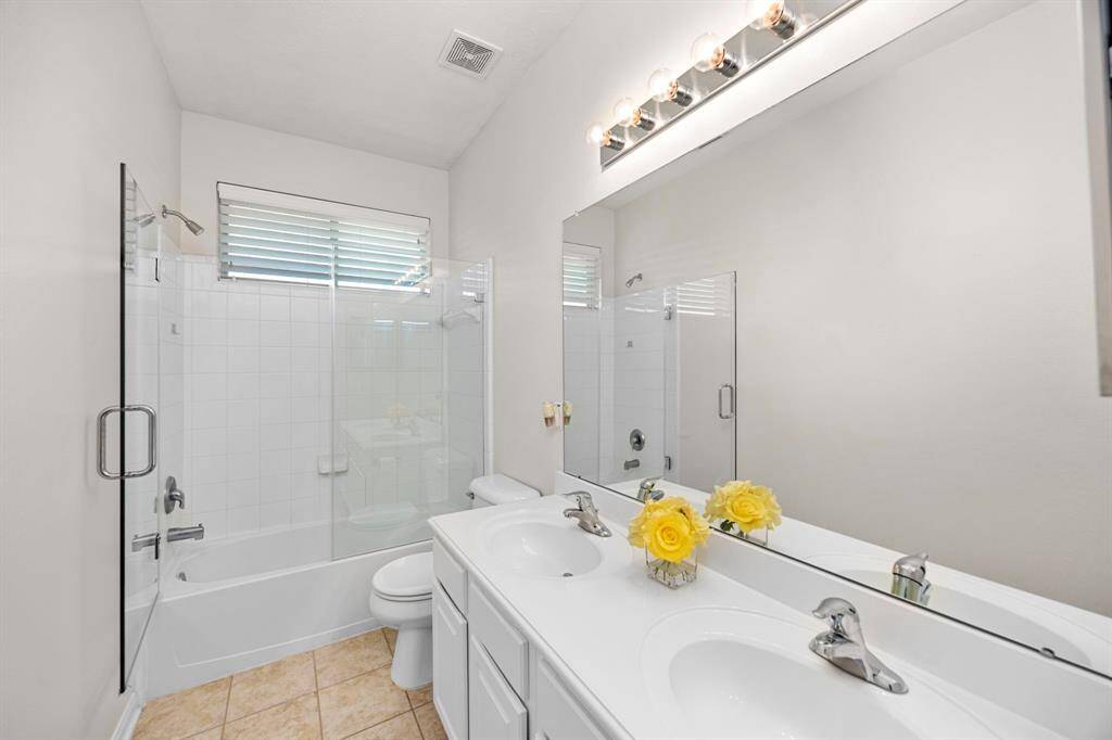 One of three guest bedrooms with custon blinds, a ceiling fan and two closets.