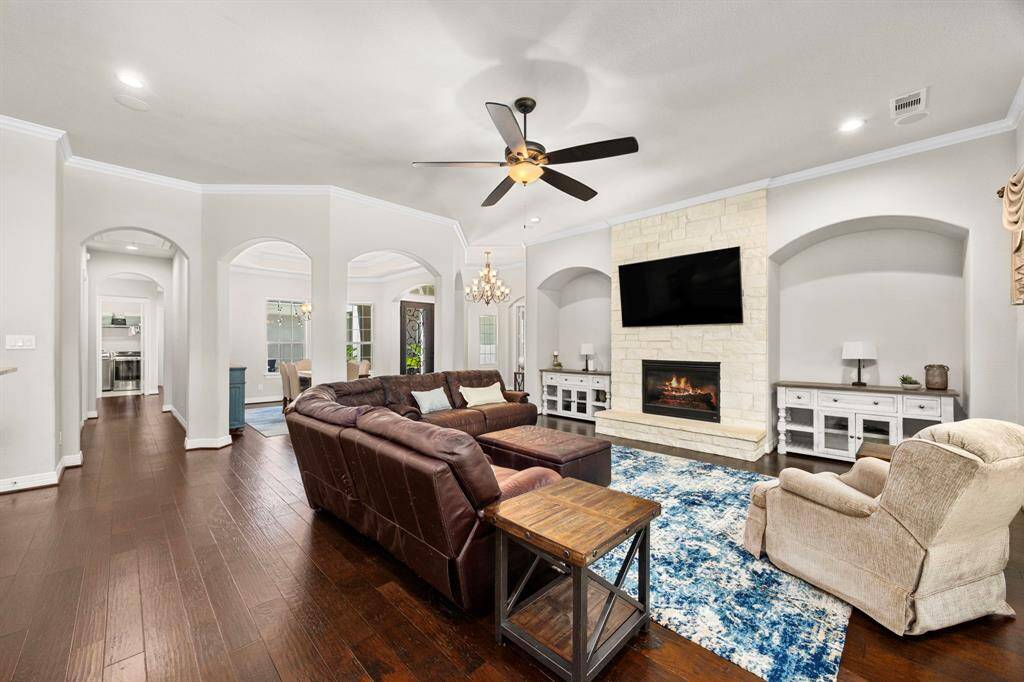 The gas log fireplace with floor-to-ceiling stone surround makes a fabulous focal point in the room, and the two arched, setback sections are the perfect complement to the room.