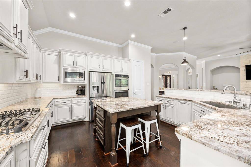 Not only are there tons of cabinets and drawers for storage, but the door on the opposite side of the kitchen next to the ovens opens to a spacious walk-in pantry.