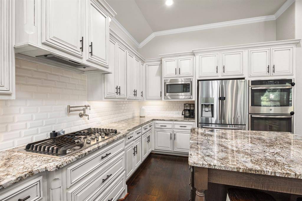 Notice the double ovens, the gas cooktop with a pan filler above,the farm-deep sink, the seperate microwave.  The shiny refrigerater/freezer will also convey with the home! What more could you want?