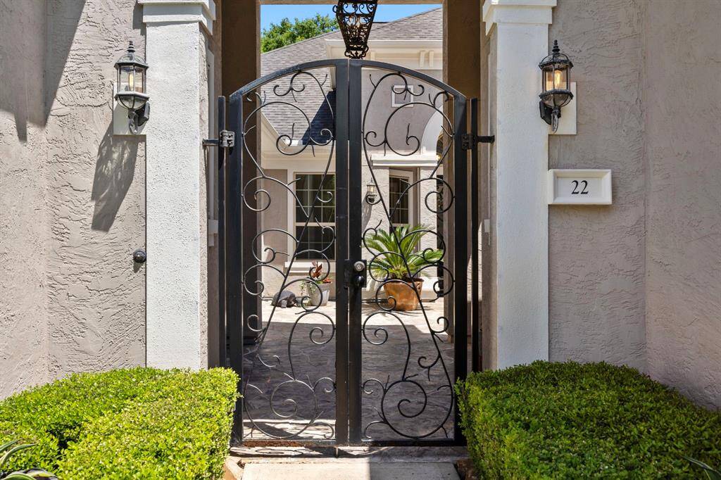 A handsome walkway leads to the iron entry gates expansive courtyard.