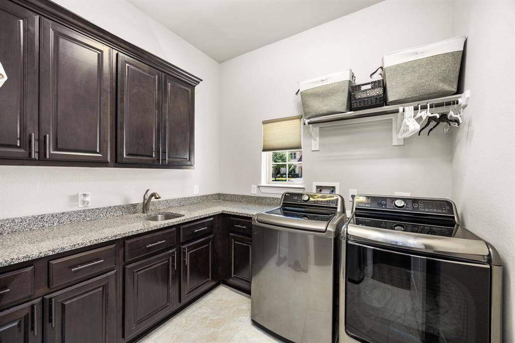 The nice sized utility room has it's own sink, lots of counterspace, and many extra cabinets. There is a window to let in natural lighting!