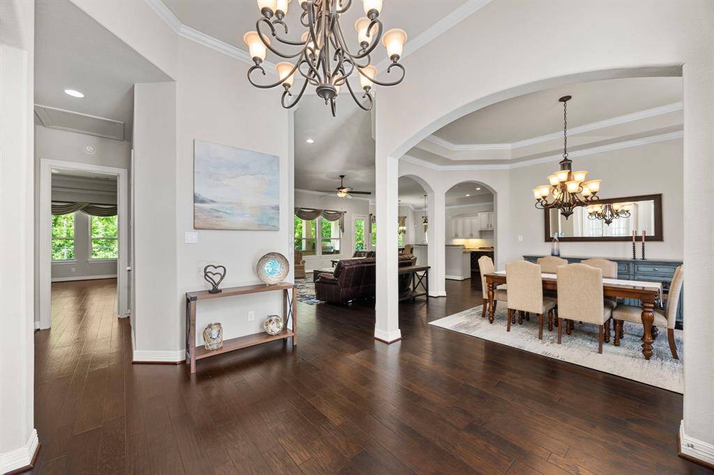 The entry view looks to the right, into the elegant, formal dining room with grand tray ceilings and double crown molding.  To the left you can see the private hallway to the secluded Primary Retreat.