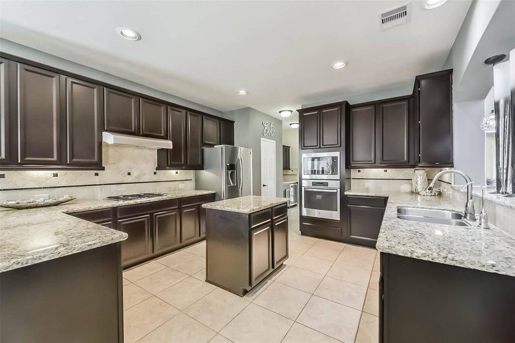 Big, inviting kitchen with abundant cabinets and a perfect-sized island for prep or casual dining.